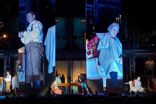 Lucas Meachem as Figaro and Philip Skinner as Dr. Bartolo projected above Meachem, Da Photo