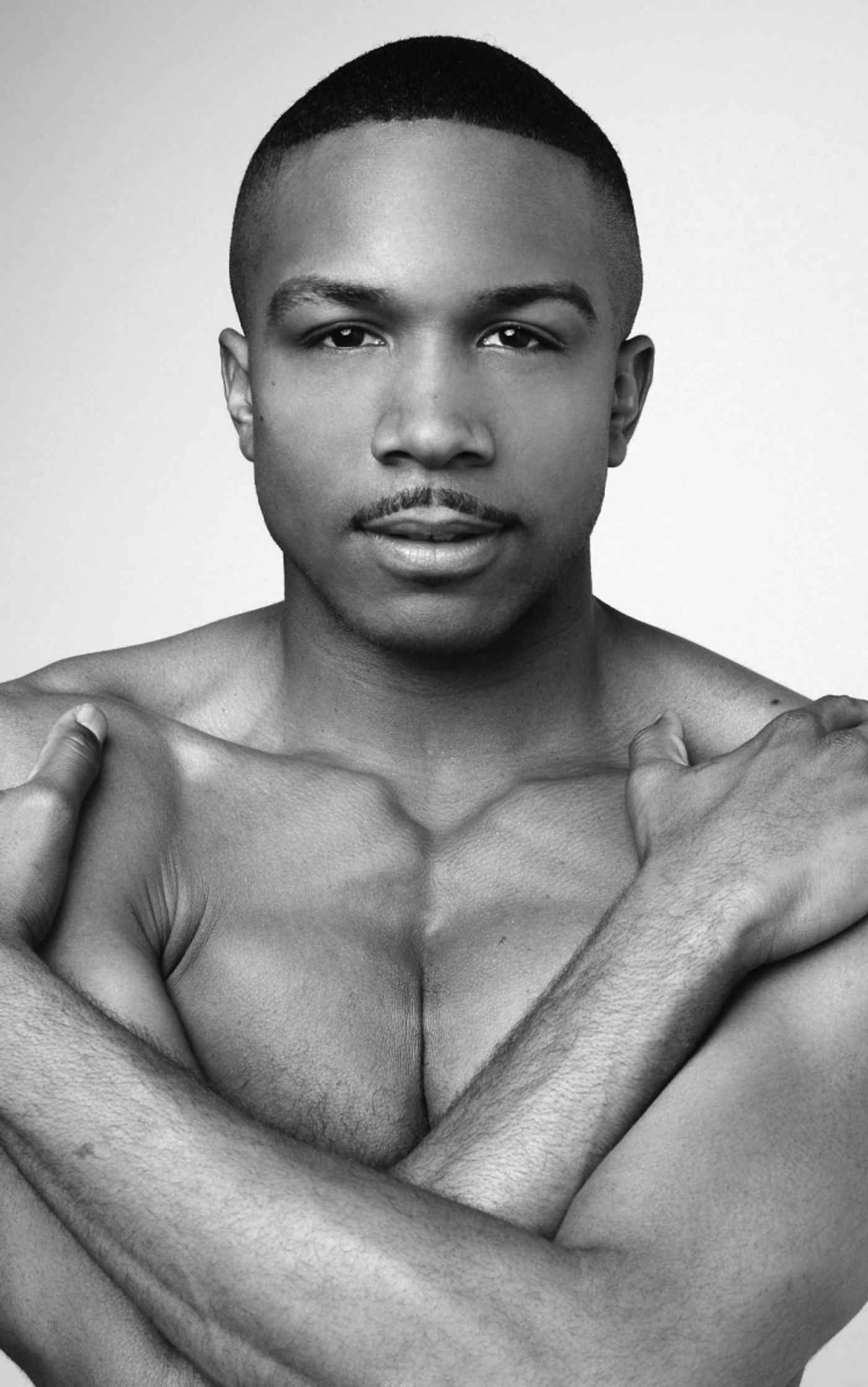 Alvin Ailey American Dance Theater's Michael Jackson, Jr., posed with arms crossed over a bare torso, gazed directed at the camera.