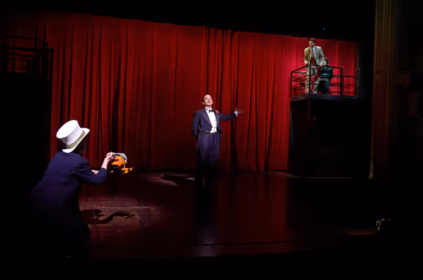 The emcee (actor, Maggie Kettering*) gives Mr. Memory (actor, Joe Wegner*) the spotli Photo