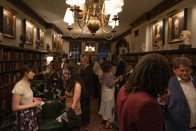 Guests mingle in the Player''s Club library.  Photo