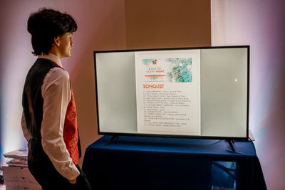 Young performer in the choir Henry Lombardo glancing at the Songlist in the Green Roo Photo