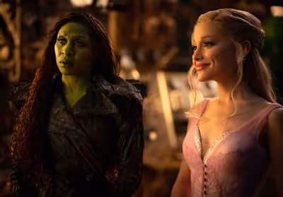L to R: Cynthia Erivo is Elphaba and Ariana Grande is Glinda in WICKED FOR GOOD, dire Photo