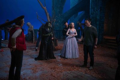 Cynthia Erivo (as Elphaba) and Ariana Grande (as Glinda) with Director Jon M. Chu  Photo