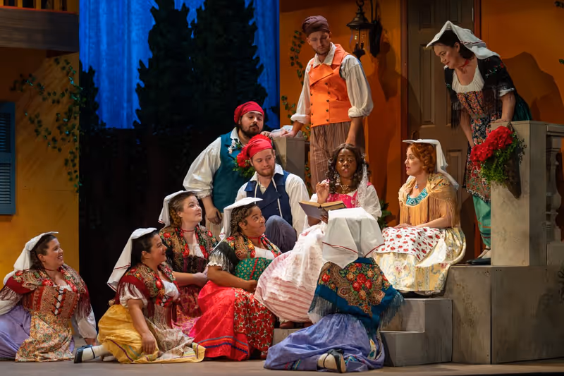Adina (Kyaunee Richardson) reads an old romance to her peasant friends.