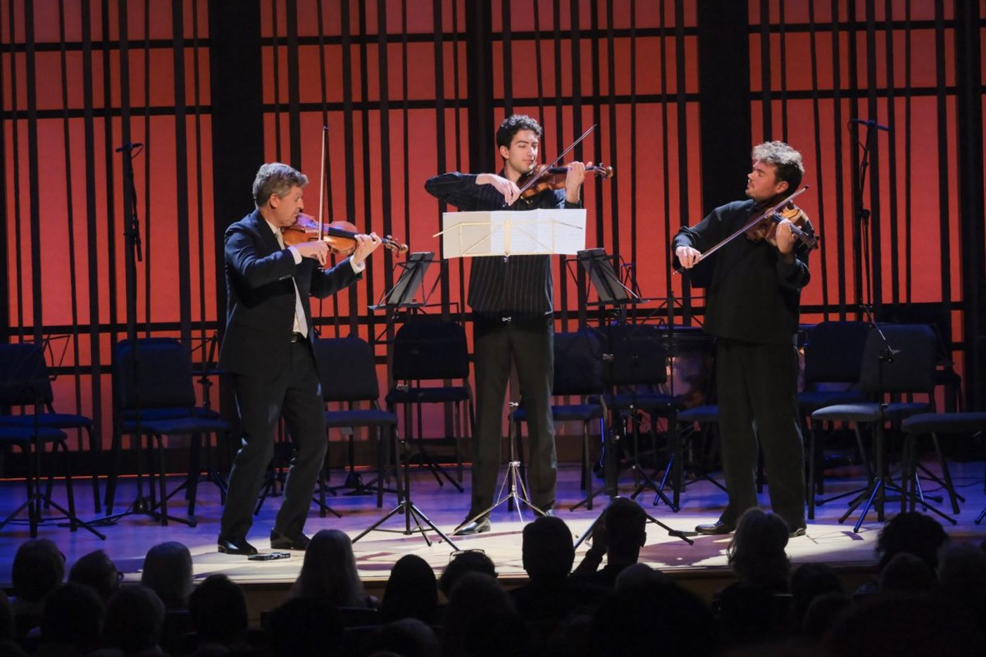 Two violinist and a viola player on stage