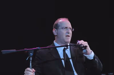 Neil Berg thanking the audience for being part of the fundraiser Photo