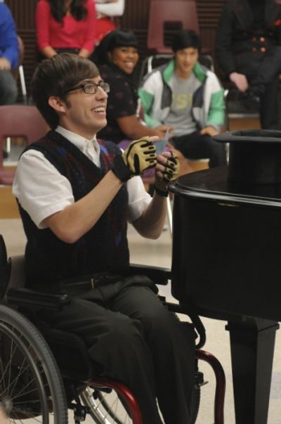 Artie (Kevin McHale) picks his singing partner's name from a  Photo