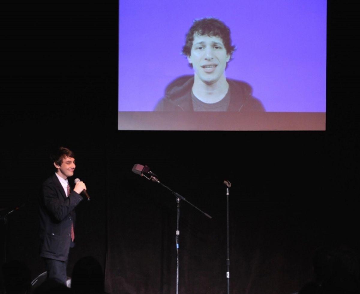 Jorma Taccone on stage; on video Andy Samberg at 