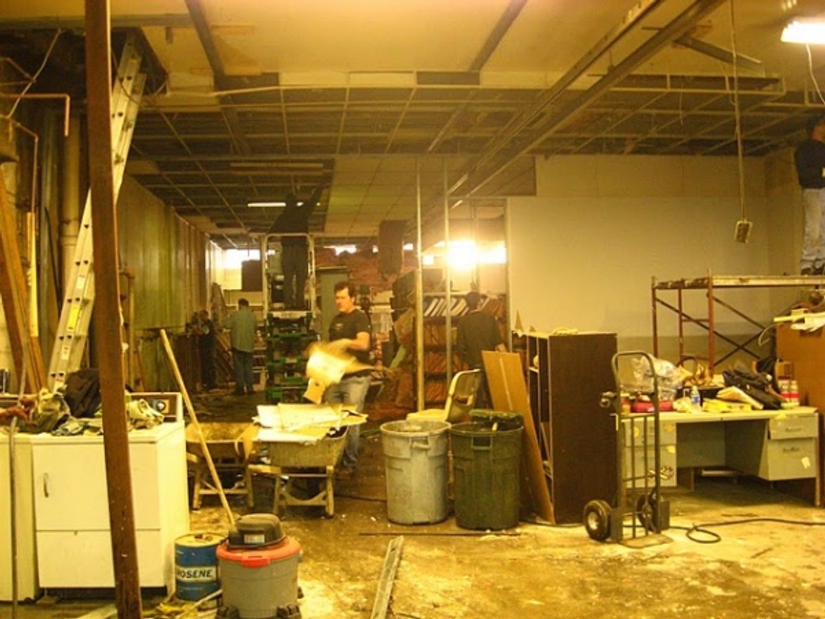 Chris Bair demolishes a wall at Madlab Theatre Undergoes Renovations