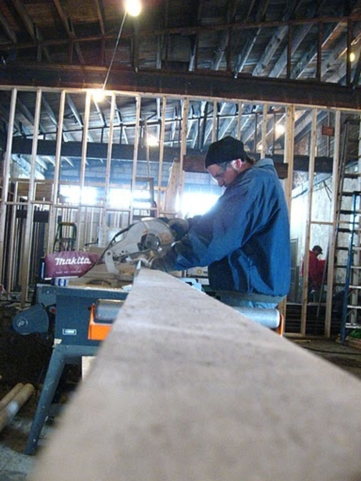 Josh Kessler cuts a piece of lumber for wall framing at 