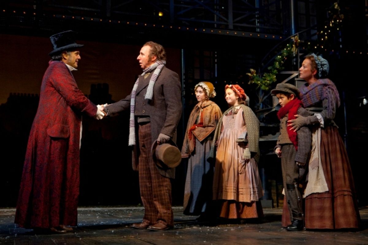 Edward Gero as Ebenezer Scrooge and Christopher Bloch as Bob Cratchit, with (background) Brooke Bloomquist as Martha Cratchit, Caleigh Davis as Belinda Cratchit, Stephen Scholl as Tiny Tim and Amy McWilliam at 