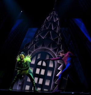 The Green Goblin (Patrick Page) duels with Spider-Man (Reeve Carney) high atop the Ch Photo