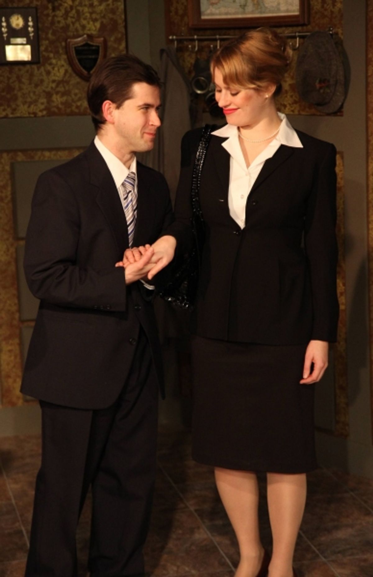 The Commissioner (Eric Pasky, left) introduces himself to the reporter (Simone Roos, right) at 