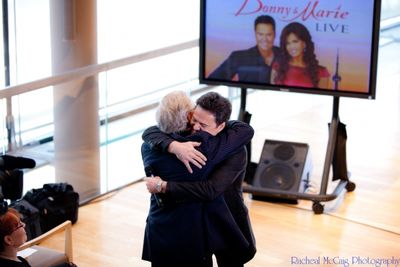 Donny Osmond and Colm Wilkinson embrace Photo