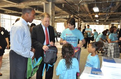 Mike Woods, Seth Diamond, Paige Davis getting help filling backpacks Photo