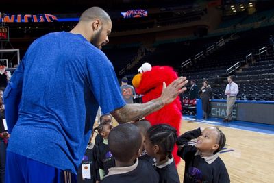 Elmo and New York Knick Tyson Chandler give high fives to children from the Garden of Photo