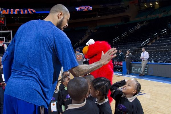 Elmo and New York Knick Tyson Chandler give high fives to children from the Garden of Photo