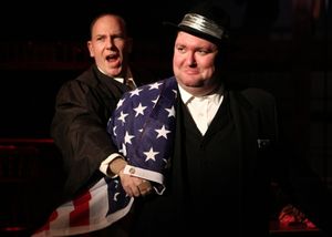 J. Edgar Hoover (E.J. Subkoviak) is wrapped in an American flag by the narrator (Jake Endres). @ BroadwayWorld J. Edgar Hoover (E.J. Subkoviak) is wrapped in an American flag by the narrator (Jake Photo