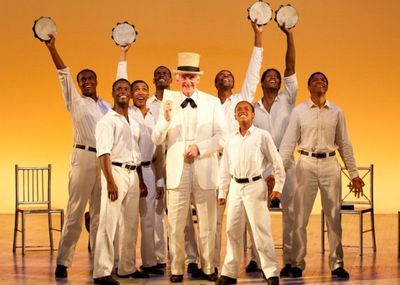Ron Holgate as The Interlocutor and Cast Photo
